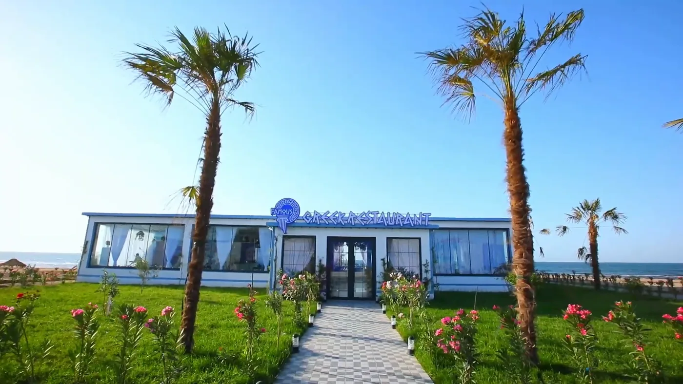 The facade with palms and the Famous Greek Restaurant sign