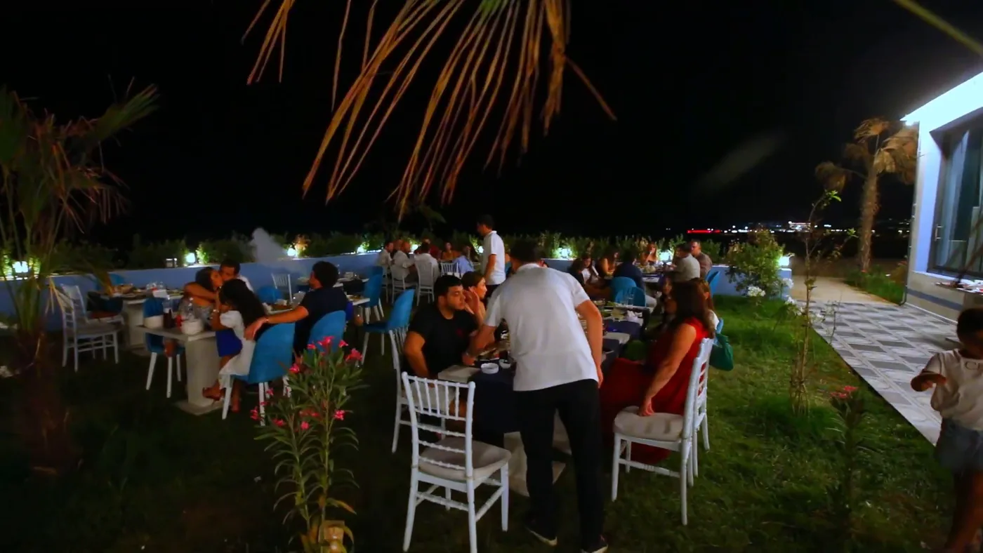 Tables on the lawn under palms in the evening