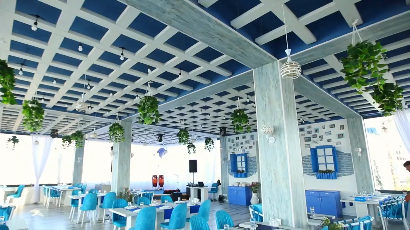 A blue-and-white pergola with hanging plants