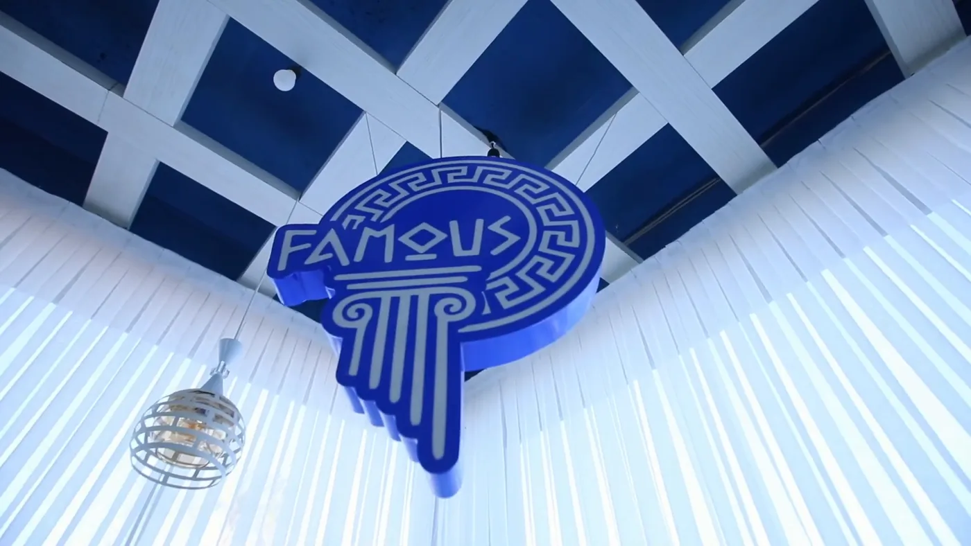 Логотип Famous под сине-белым потолком